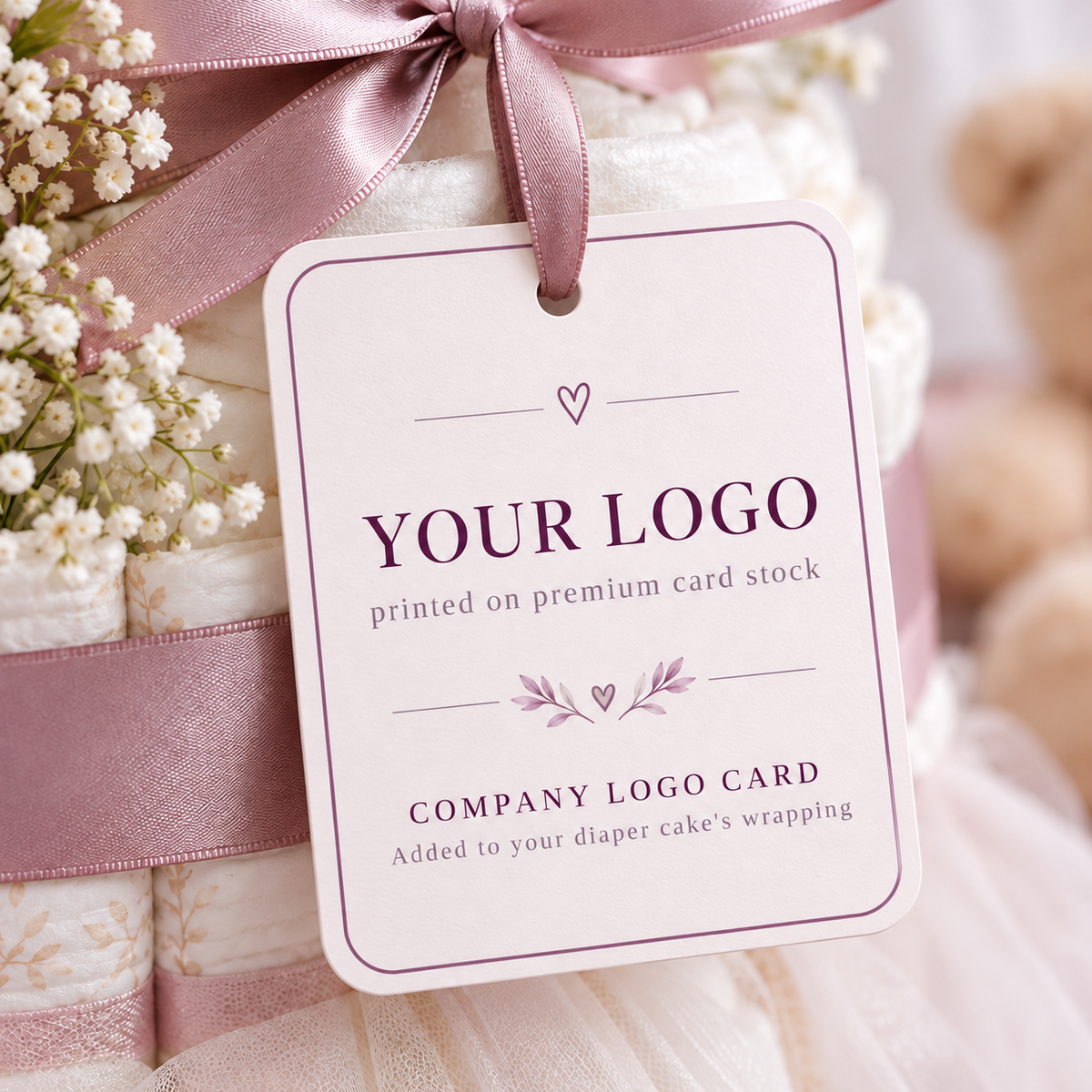 Company logo card on premium card stock tied to a diaper cake with a mauve ribbon