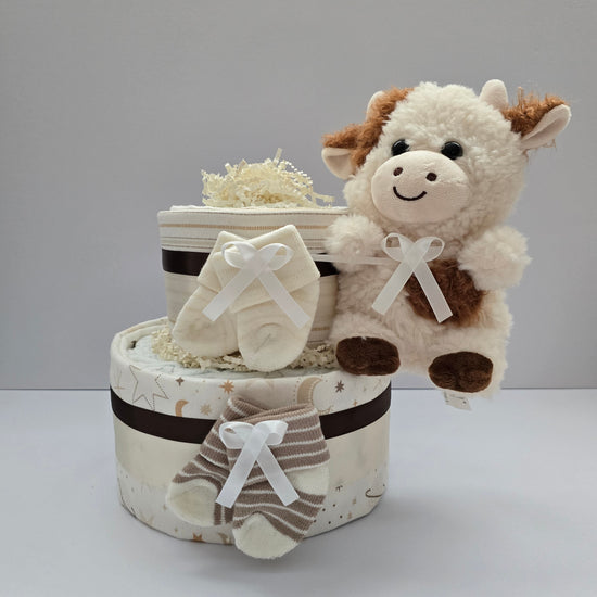 Sweet Little Moo Moo Cow mini diaper cake with two tiers in neutral cream and brown, baby socks, ribbon bows and a plush cow