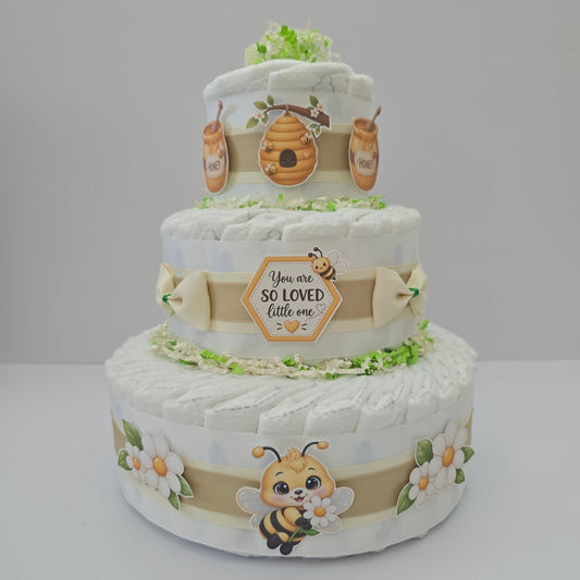 Sweet as Can Bee three-tier diaper cake made with premium Size 1 diapers, soft neutral ribbons, adorable bee, honey and floral decorations, displayed at a beautiful bee-themed baby shower